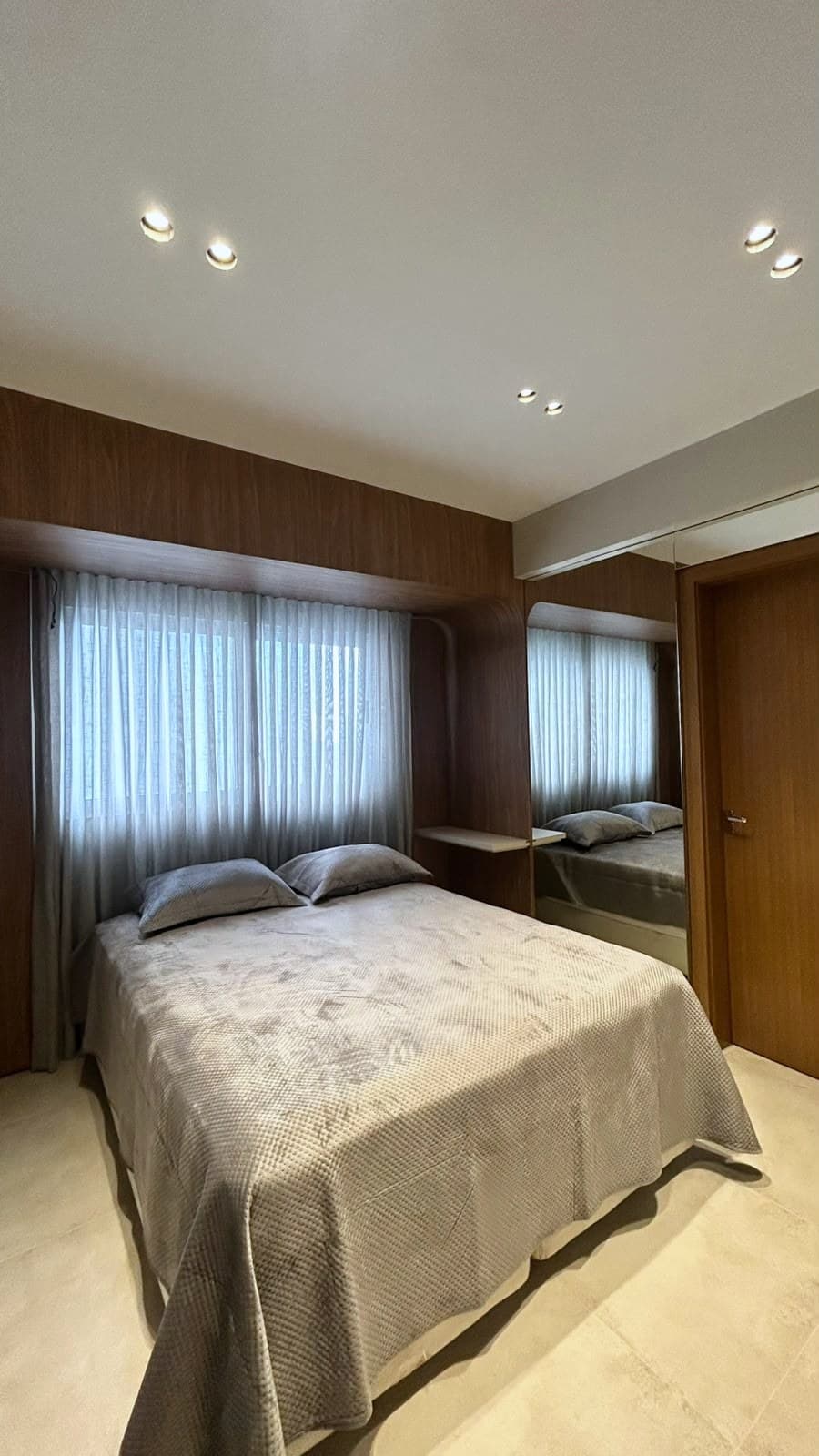 Suíte com armário espelhado e cortina sheer